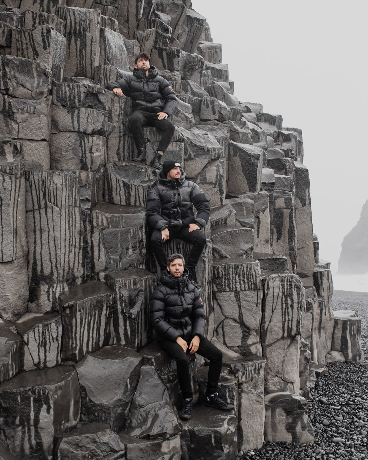 The three members of Meduza sitting on the basalt columns at Reynisfjara black sand beach in South Iceland