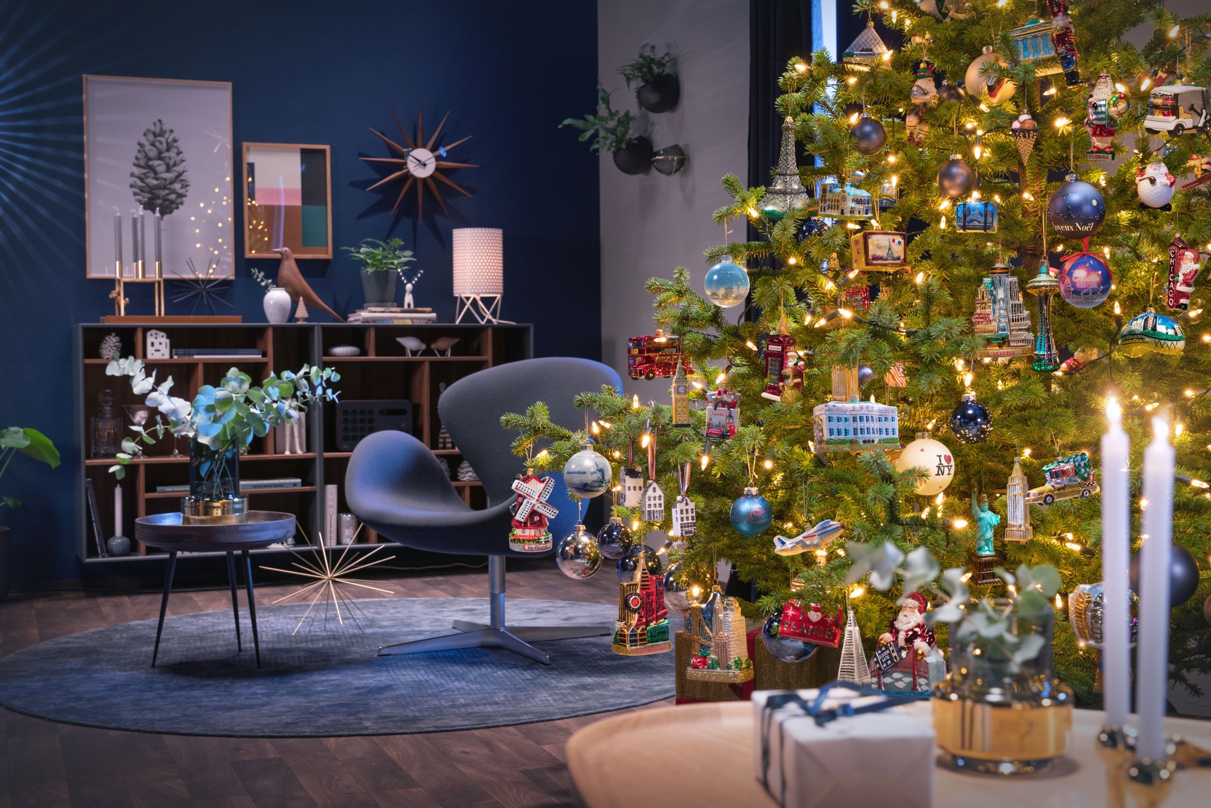 a cosy livingroom scene with designer Scandanavian decor and a large bright Christmas tree