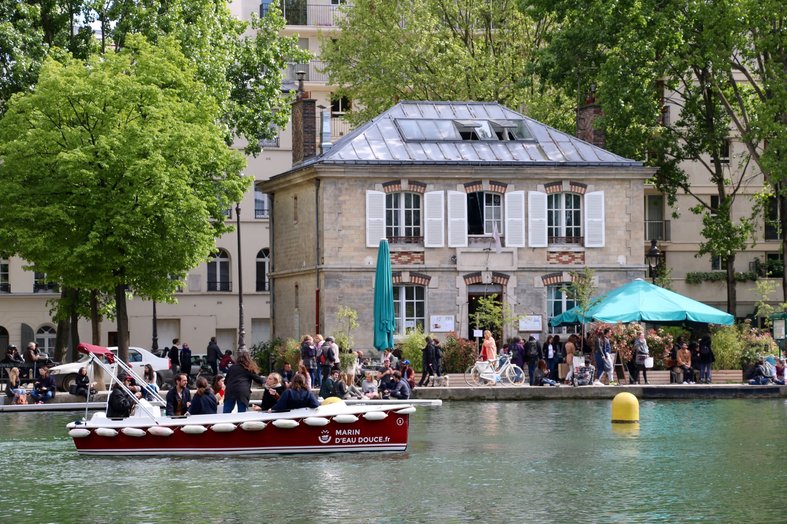 The canal de l'ourcq in Paris with a bustling cafe and riverway