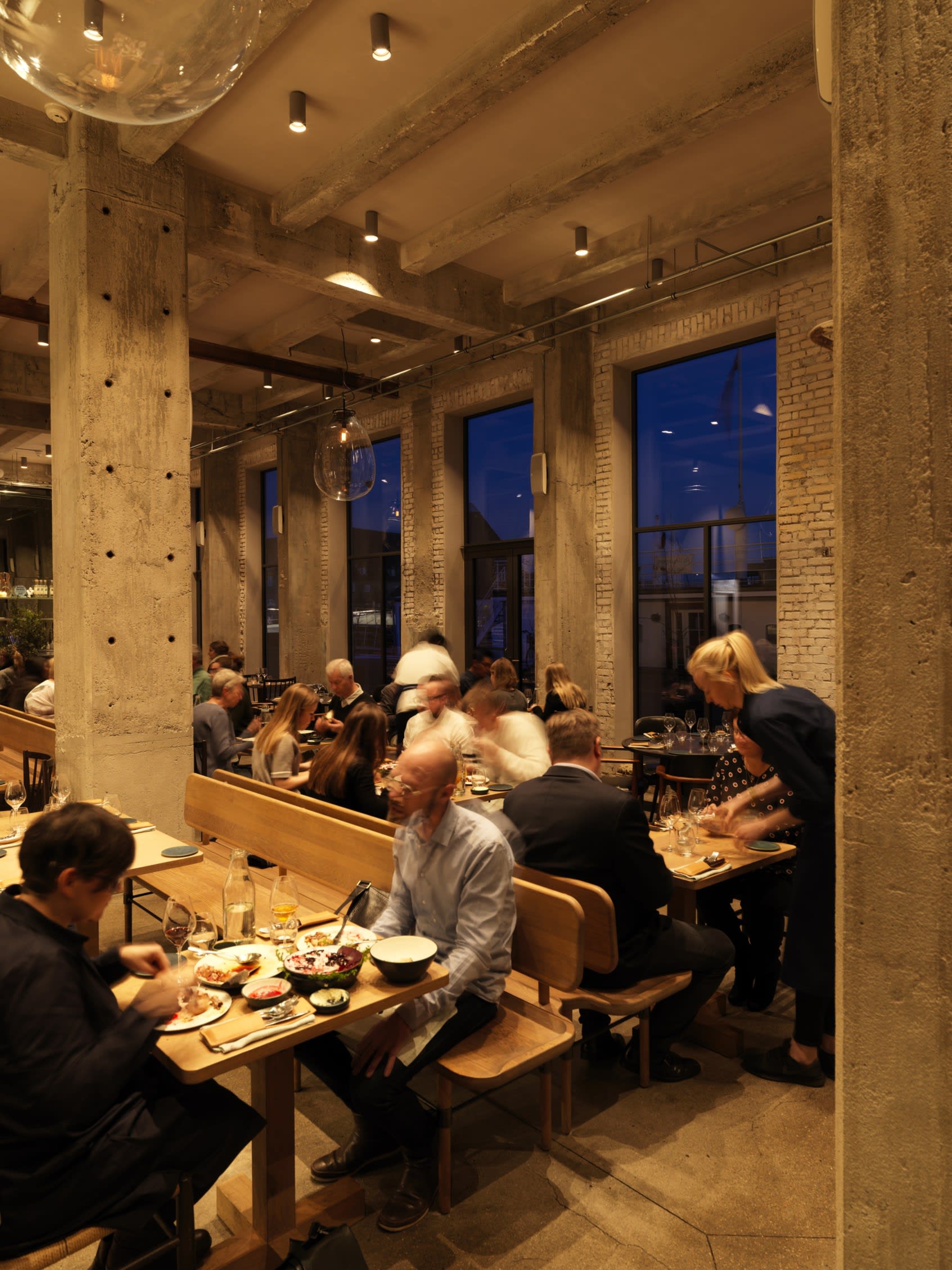 a bustling restaurant called 108, where diners eat at rows of wooden tables with benches