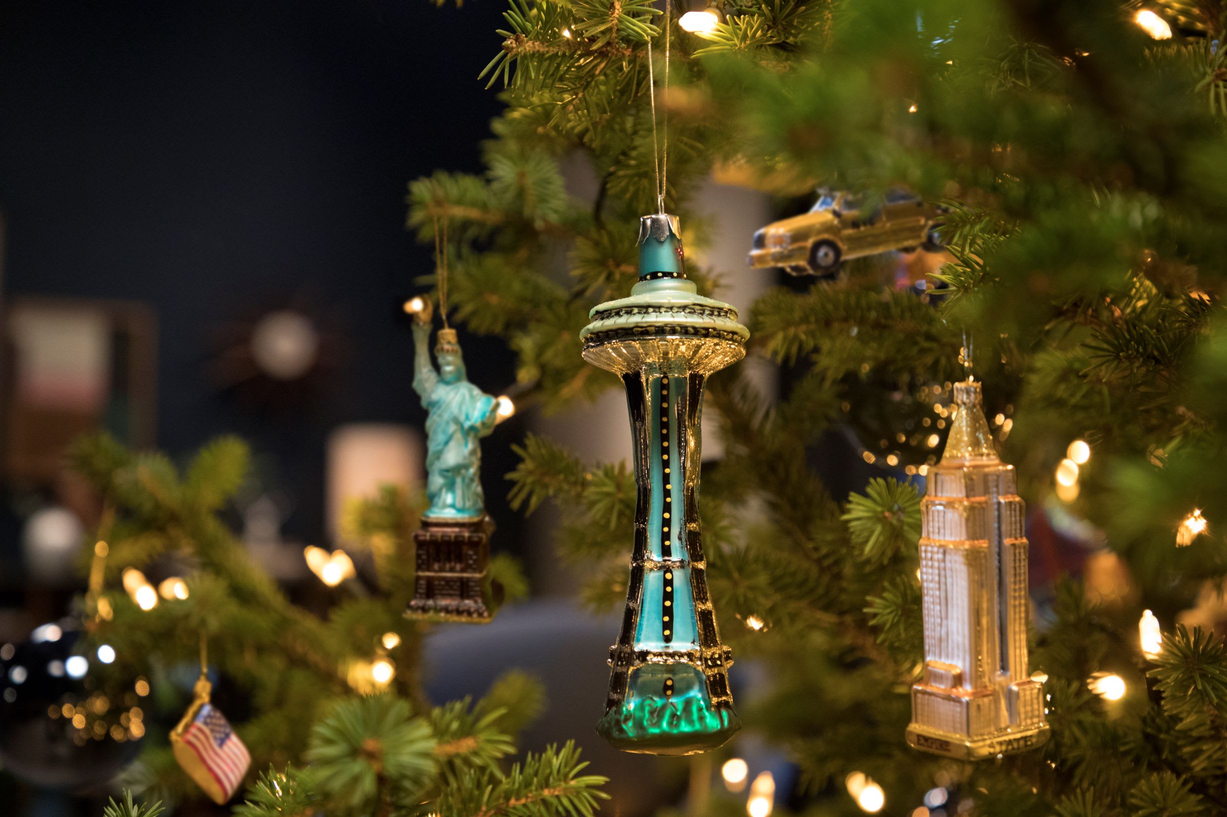 a collection of Christmas decorations on a tree, one being the Seattle needle and another being the statue of liberty