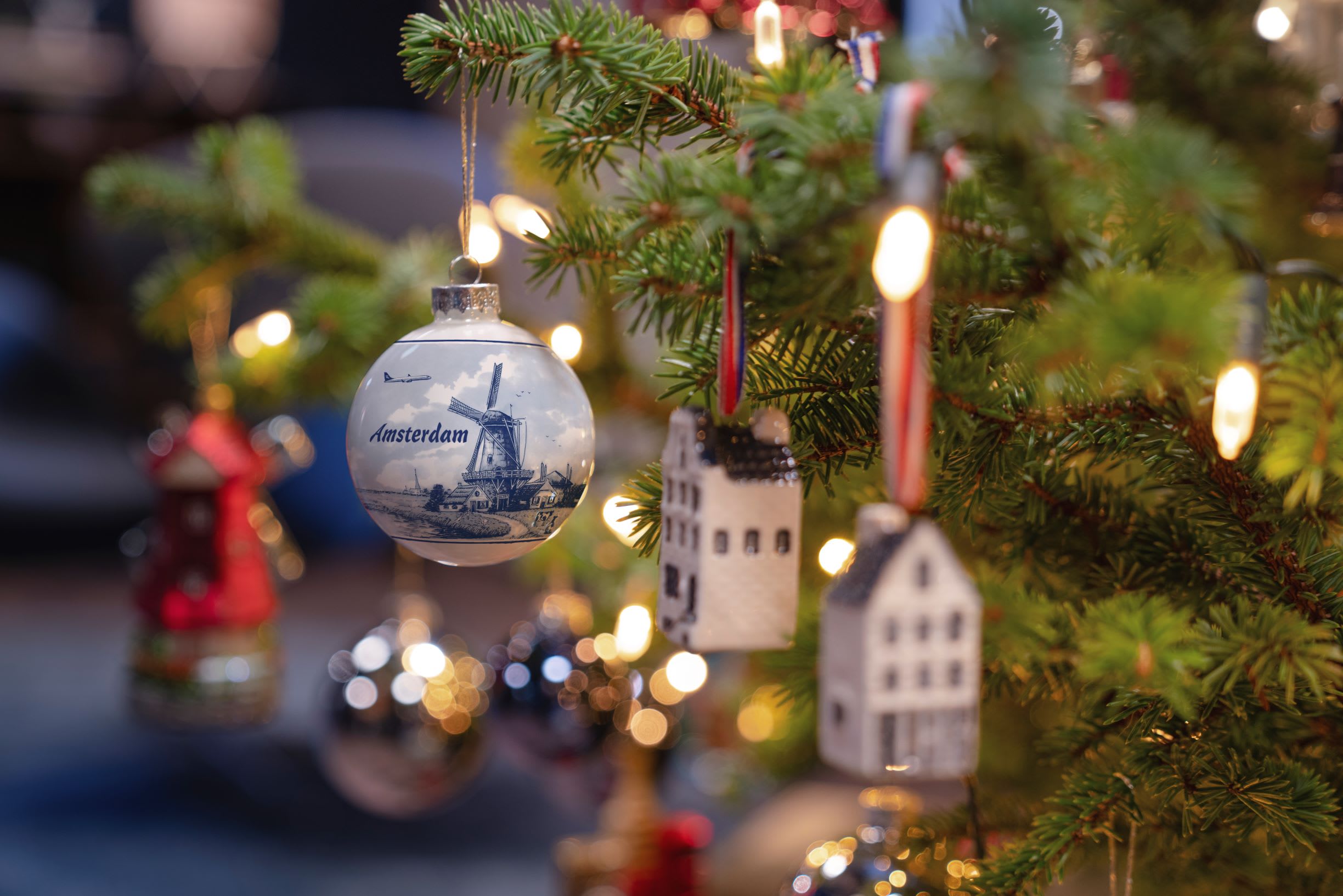 an up close of a Christmas tree with a bauble with a windmill on it and copy that reads 'Amsterdam'