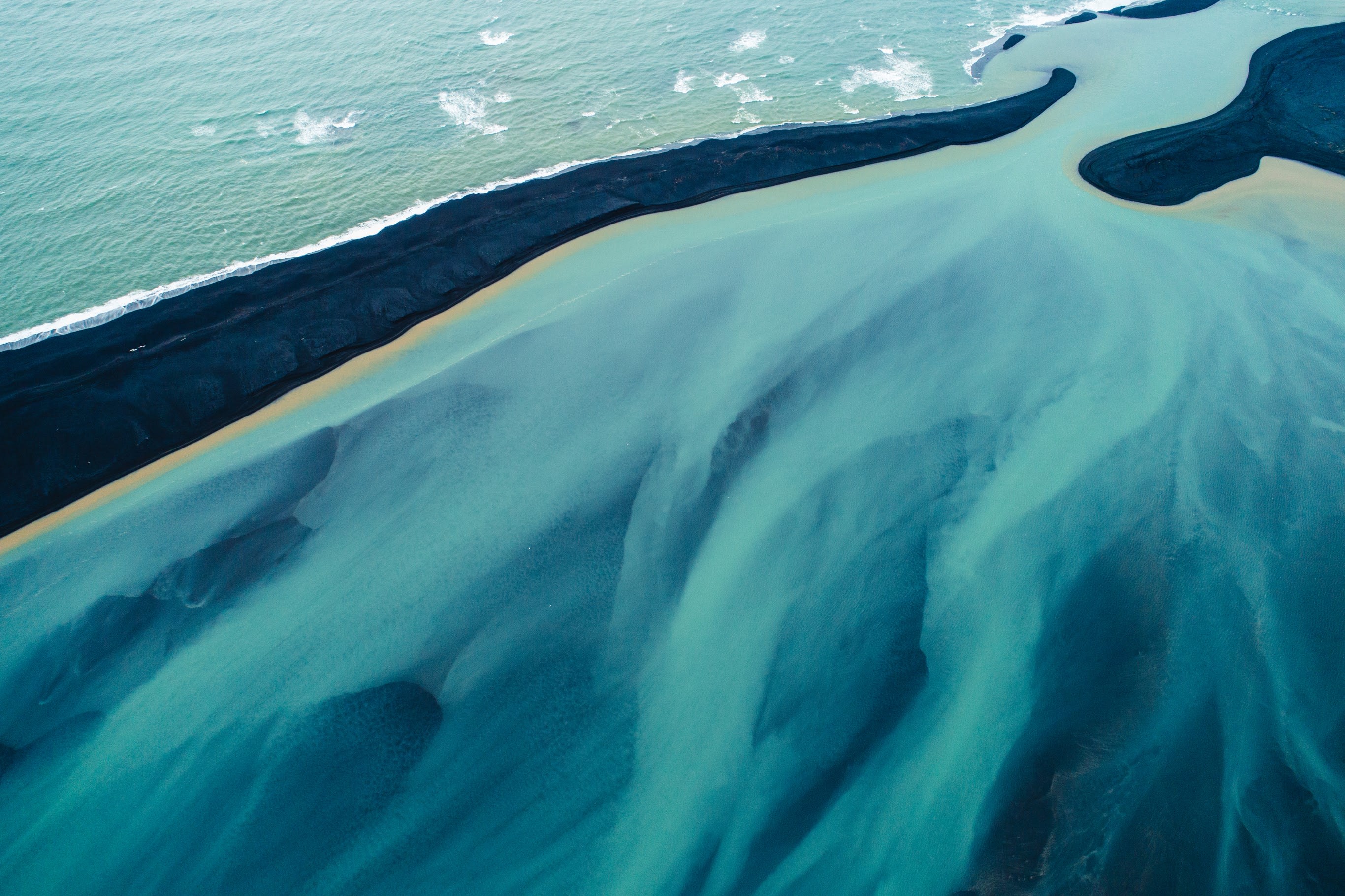 an aerial view of the bright blue glacial rivers in Iceland