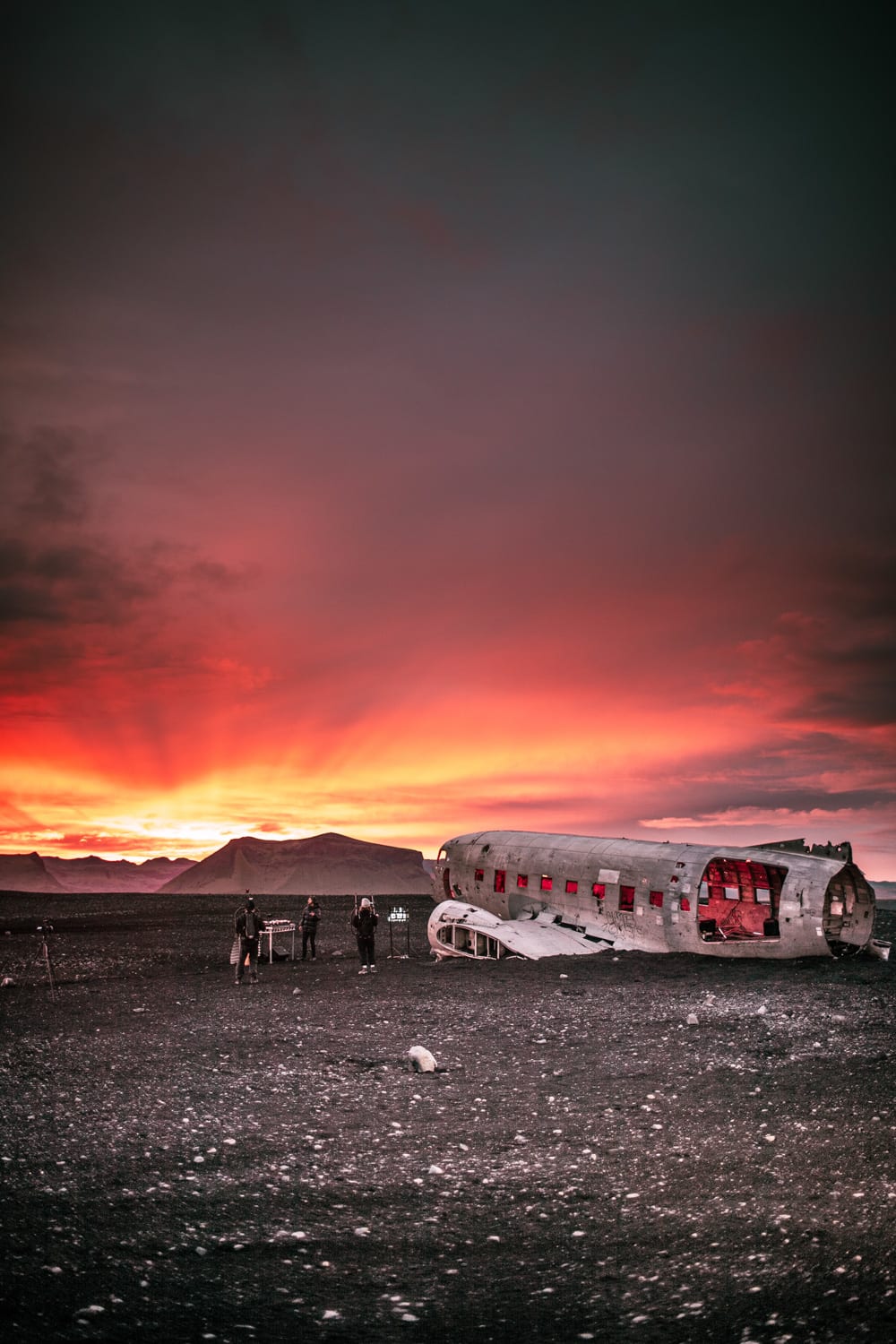 The band Meduza performing at the abandoned aircraft in the South of Iceland during a beautiful red sky sunset