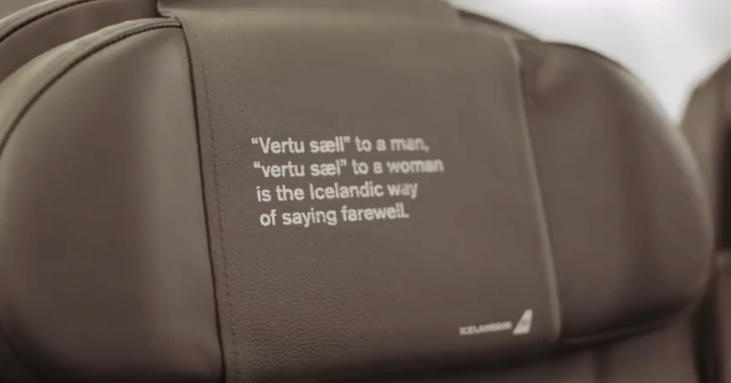The back of the seat on an Icelandair flight with text that reads 'vertu sæll to a man, vertu sæl to a woman is the Icelandic way of saying farewell'