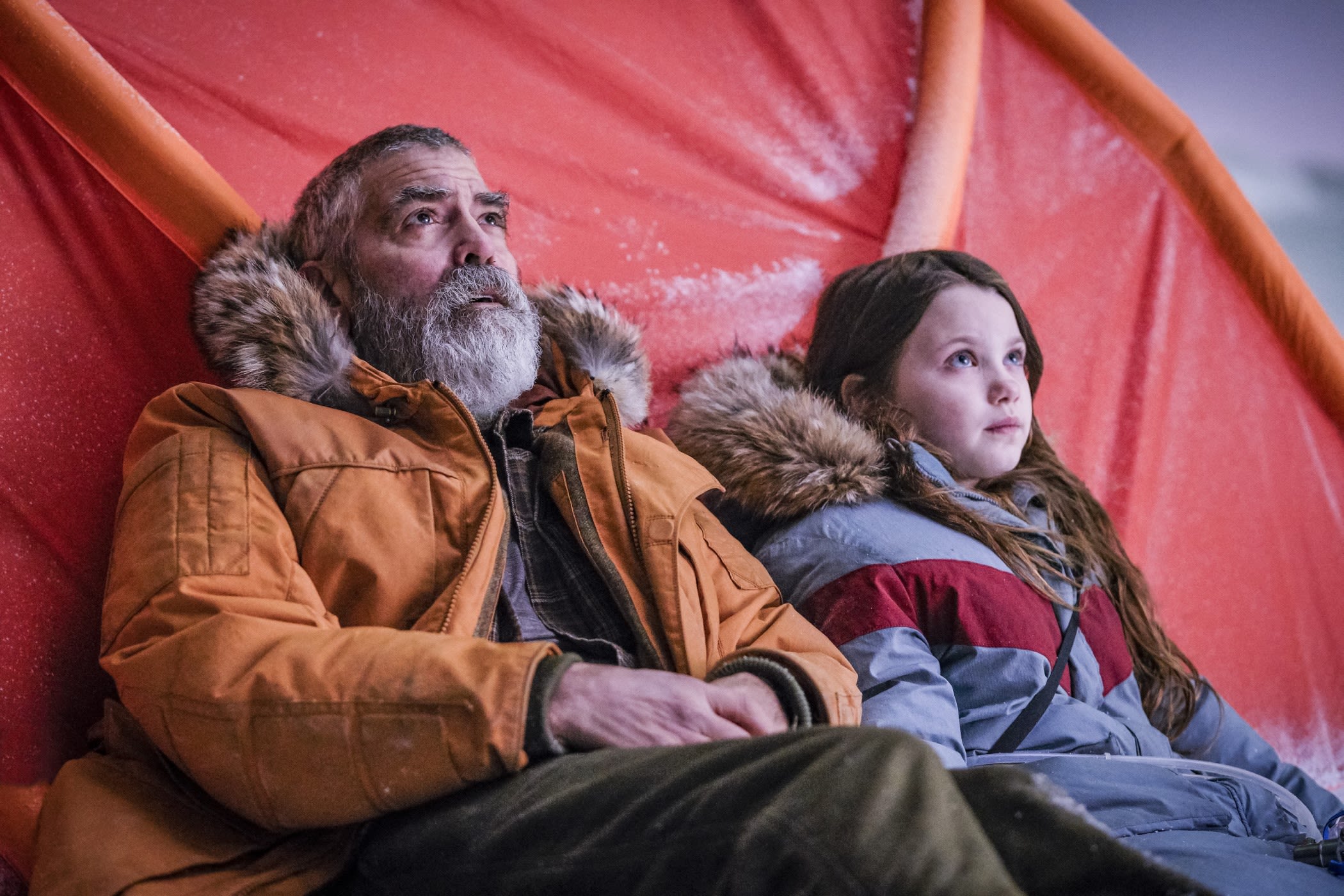 George Clooney pictured next to seven year old actress, Iris, leaning against a red tent-like structure