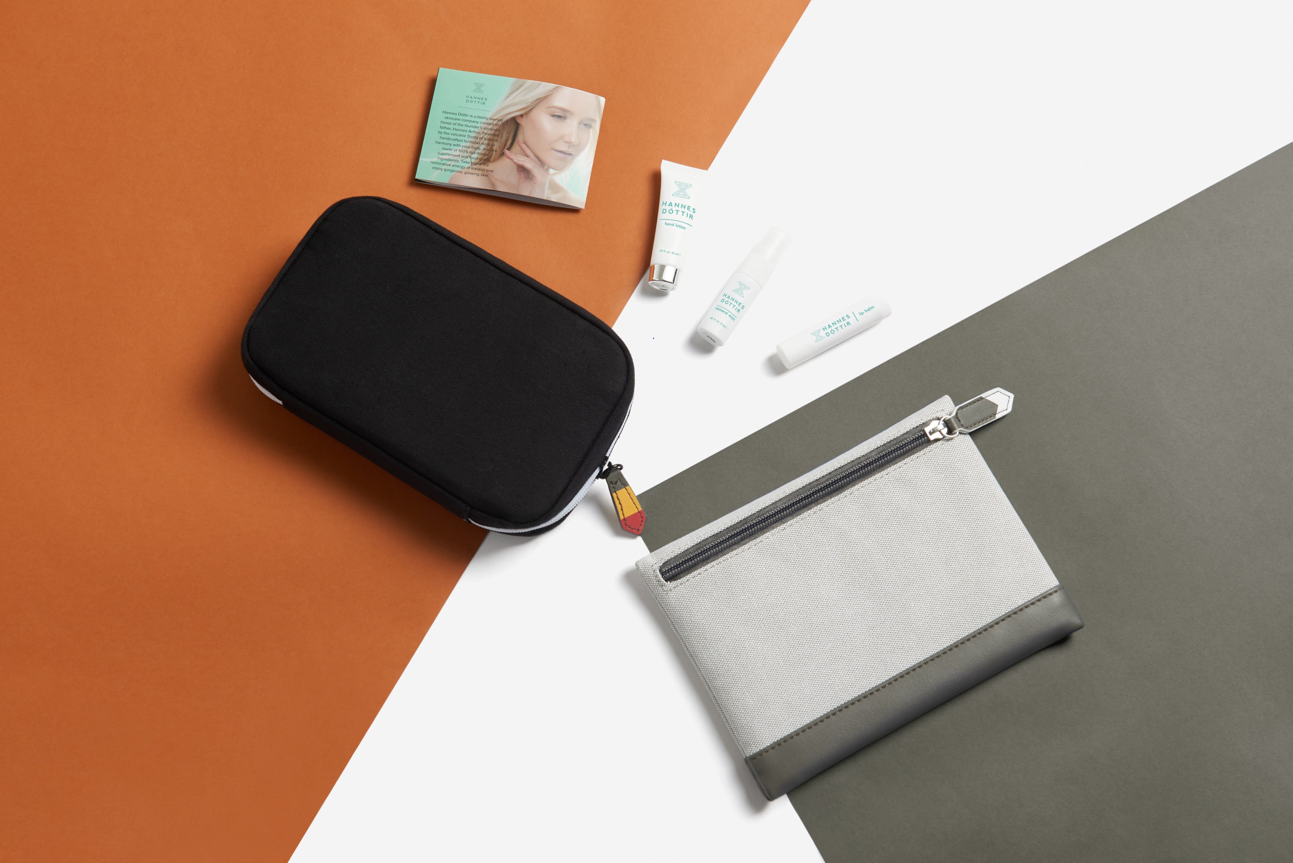 Two Icelandair amenity kit bags placed against grey, white and orange colour blocks