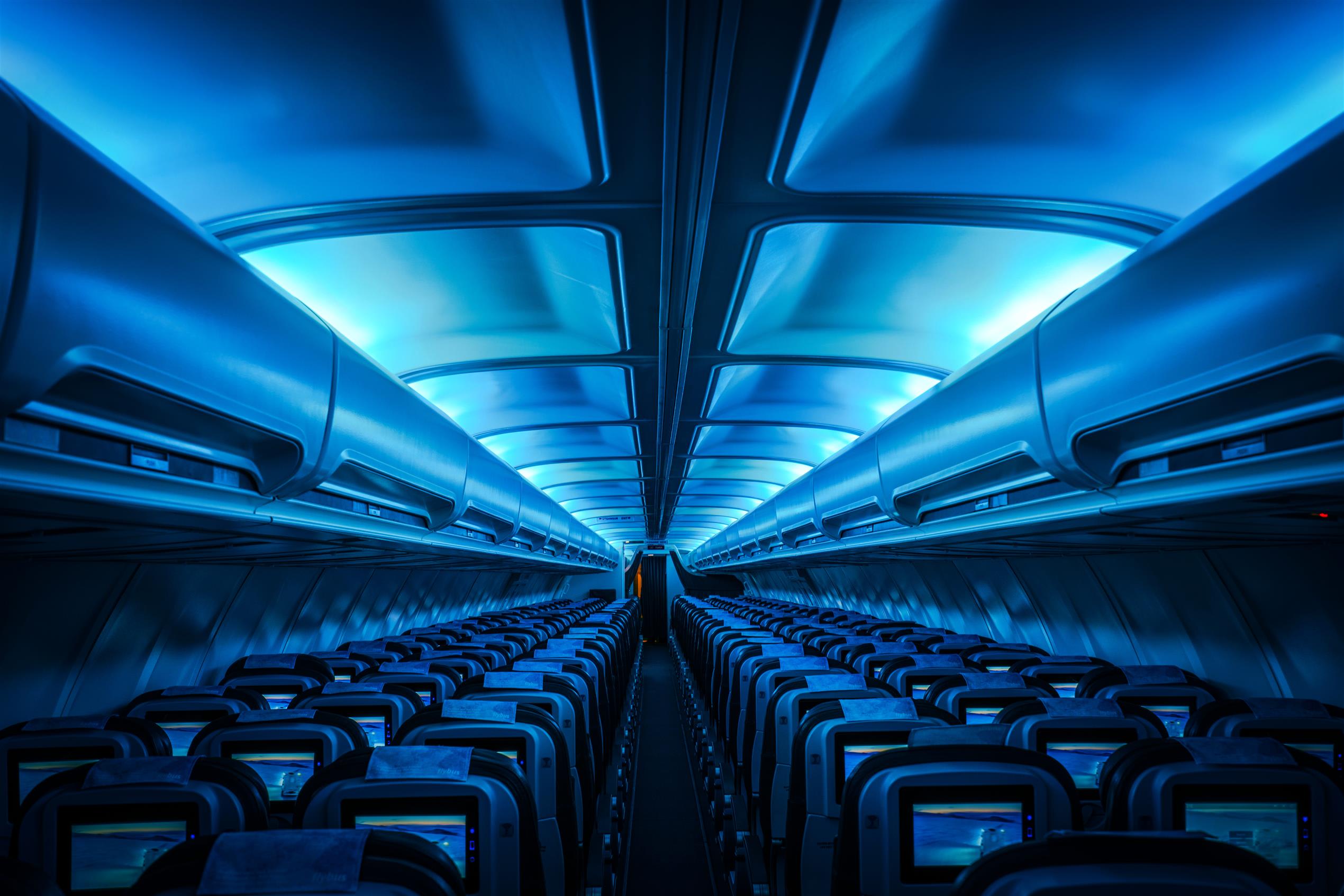 the inside of stand empty Icelandair aircraft lit up by dimmed blue overhead lights