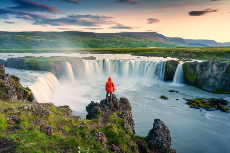 Person red coat waterfall goðafoss Iceland