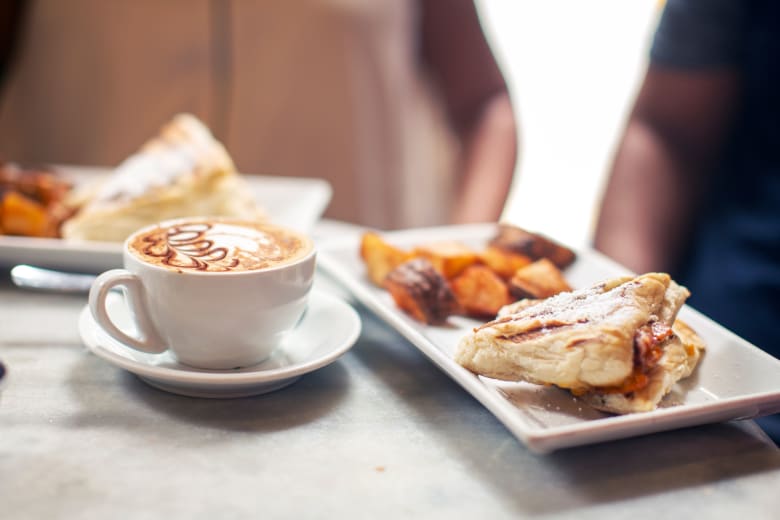 A white coffee cup and a plate of food
